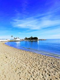 Scenic view of beach against blue sky