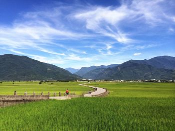 Scenic view of grassy field against cloudy sky