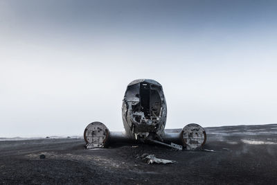 Abandoned truck on field against clear sky