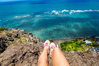 Low section of woman sitting over sea