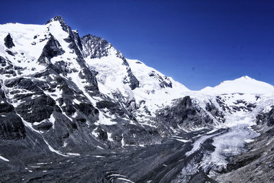 Scenic view of snowcapped mountains against clear blue sky