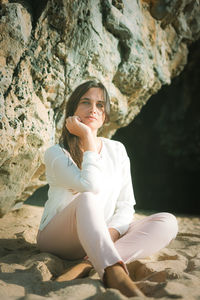 Young woman sitting on sand
