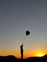 Low angle view of hot air balloons against sky during sunset