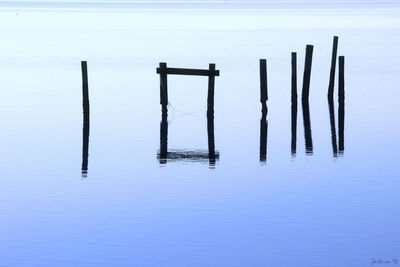 View of wooden posts in sea