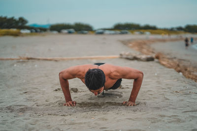 Full length of shirtless man on beach