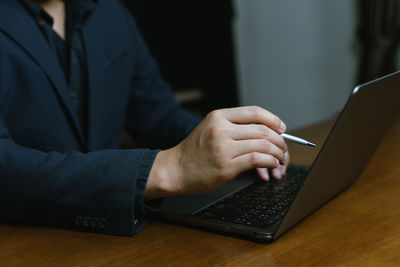 Midsection of man using laptop on table