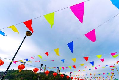 Low angle view of multi colored bunting flags against sky