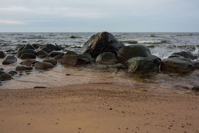 Rocks on beach against sky