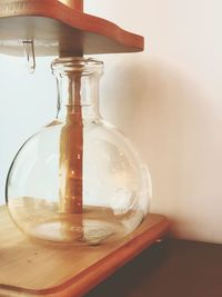 Close-up of glass jar on table against wall