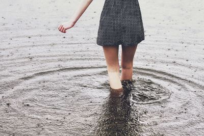 Low section of woman standing in lake