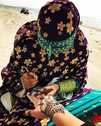 Midsection of woman holding umbrella on land