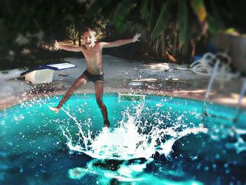 Woman jumping in swimming pool