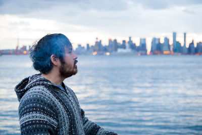 Side view of man in city against sky