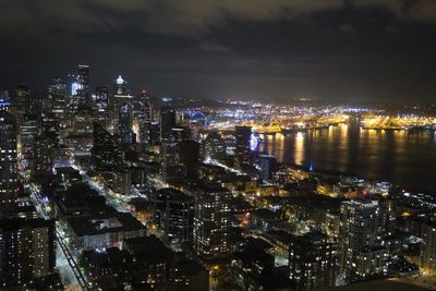 Illuminated cityscape against sky at night