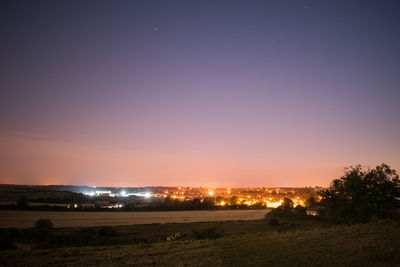 Illuminated cityscape against sky at night