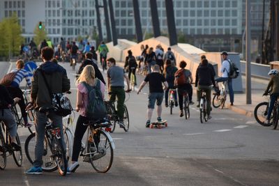 Crowd with bicycles and skateboard on street