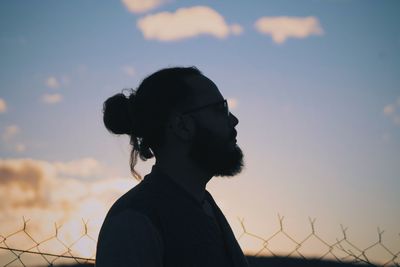 Portrait of silhouette bearded mn standing against sky during sunset