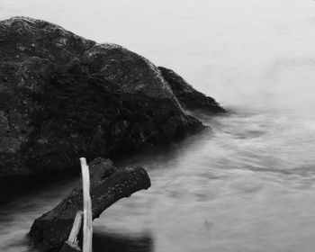 Rock formation in sea against sky