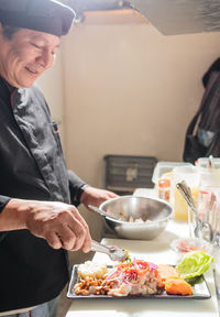 Smiling chef preparing food in kitchen