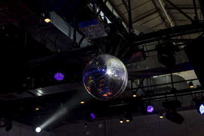 Low angle view of illuminated lighting equipment hanging on ceiling