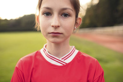 Portrait of confident female soccer player standing on field