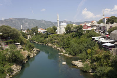 River amidst buildings in city against sky