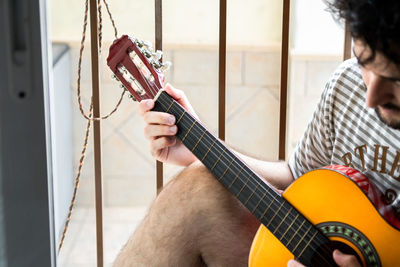 Man playing guitar at home