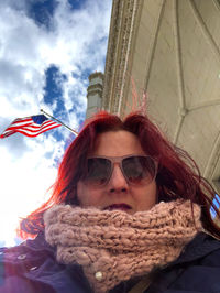 Low angle portrait of woman wearing sunglasses against sky