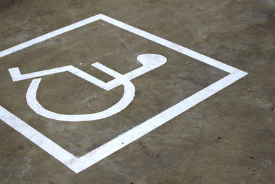 Close-up of disable symbol on parking lot