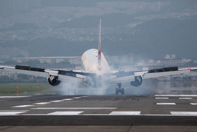 Airplane flying over runway against sky