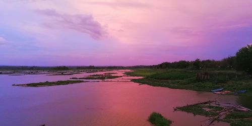 Scenic view of river against sky at sunset