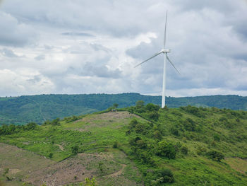 Wind turbines on land against sky