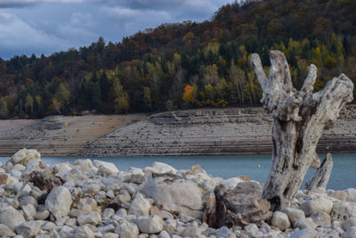 Scenic view of rocks by lake against sky