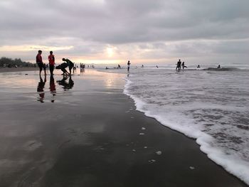 People on beach against sky