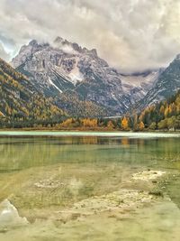 Scenic view of lake by mountains against sky