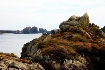 Rock formations by sea against sky