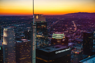 Aerial view of city lit up at sunset