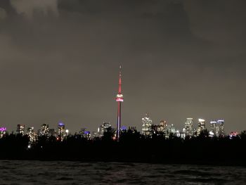 Illuminated buildings in city against sky at night