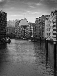 Buildings in city against cloudy sky