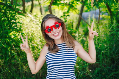 Portrait of a smiling young woman holding plants