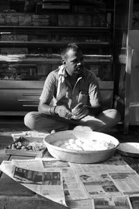 Full length of man sitting on table