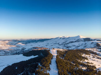 Scenic view of snow covered landscape against clear sky