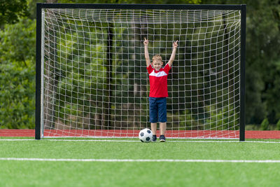 Boy playing soccer ball on field