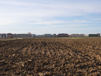 Agricultural field against cloudy sky