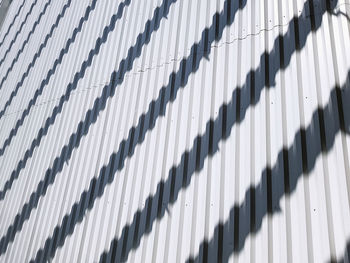 Full frame background of striped shadows on white corrugated wall