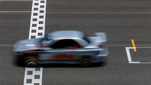 Race car blurred motion crossing the finish line on international circuit speed track, motion blur.