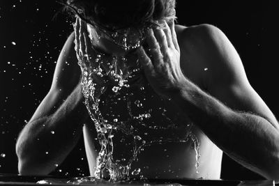 Man splashing his face with water in bathroom