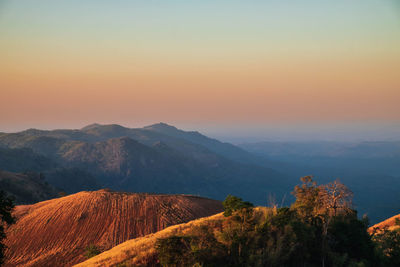 Scenic view of mountains against orange sky