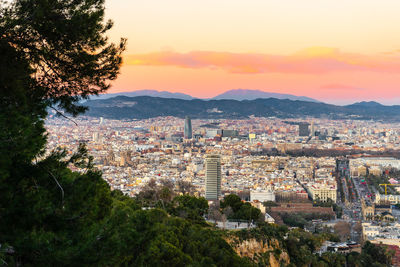 Cityscape fo barcelona, roads, buildings, mountains and sunset