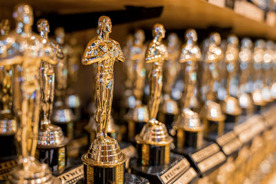 Hollywood golden oscar academy trophies arranged on shelf for sale in shop